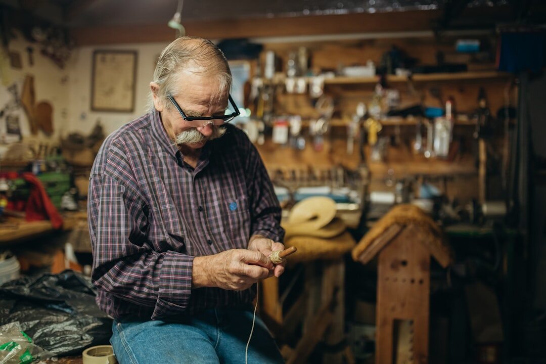 Elderly Danish male craftsman working with wood tools in his workshop