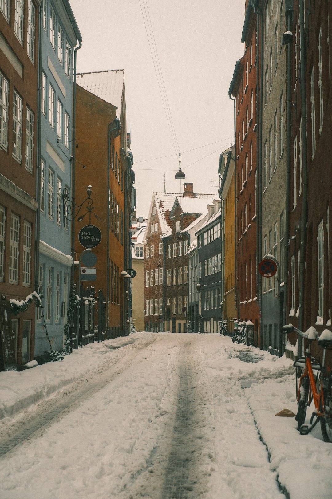 Photographer with camera walking through a small Danish town street